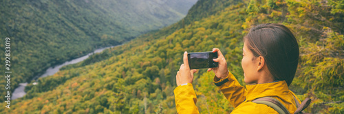 Travel hike woman hiker taking photo with phone of landscape of trail hiking in Quebec autumn foliage background panoramic banner. Canada fall camping lifestyle.