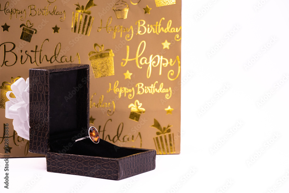 Obraz premium Cinnamon stone ring in lather gift box and carry bag on white background. Happy birthday concept