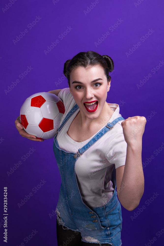 Joyful woman holding a soccer ball over isolated blue wall at studio Joyful woman holding a soccer ball over isolated blue wall at studio