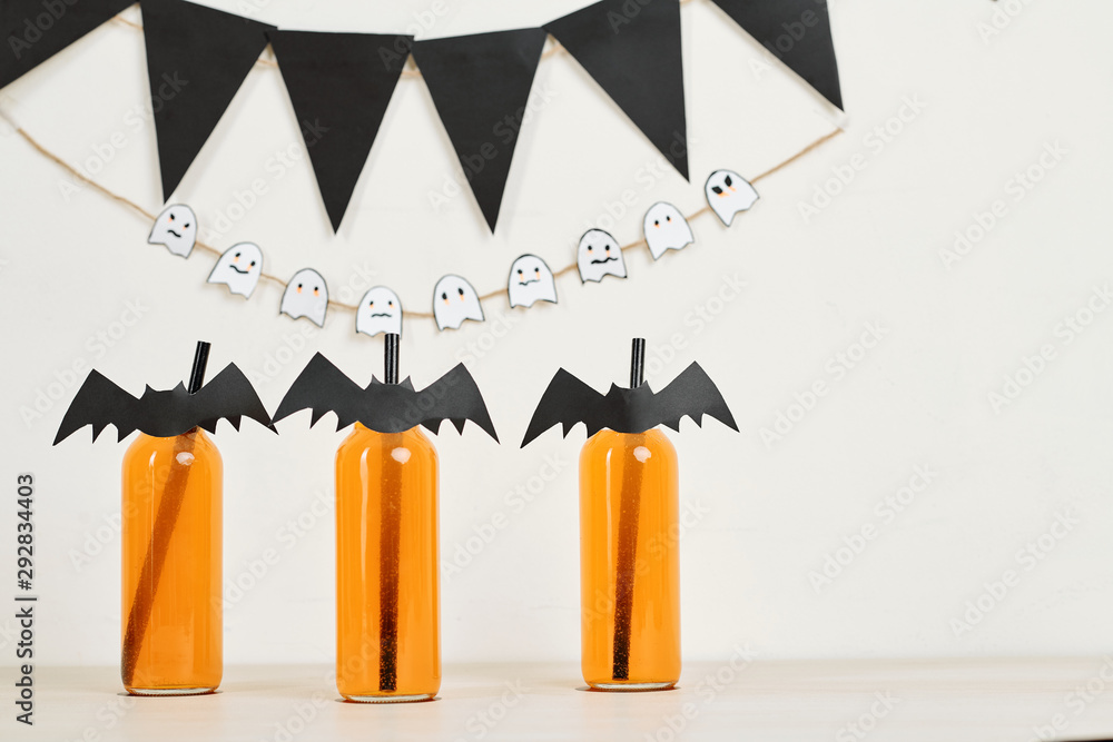 Decorated cocktail bottles with paper bats attached to straws at Halloween party Decorated cocktail bottles with paper bats attached to straws at Halloween party