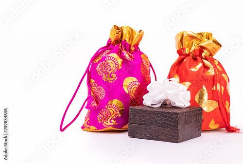 Potli bag or Dawstring bags and lather gift box decorated with white ribbon on white background