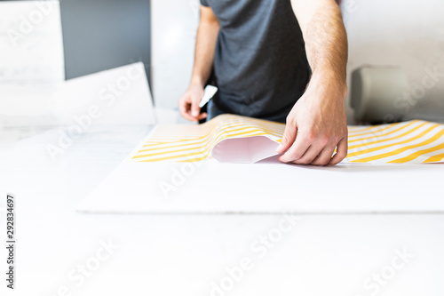 Wrapping with adhesive foil .Advertising studio. Sticking with self-adhesive foil.