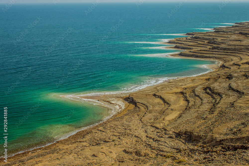 Dead sea aerial landscape photography from above with view on shore line cliff with white waterfront from salt