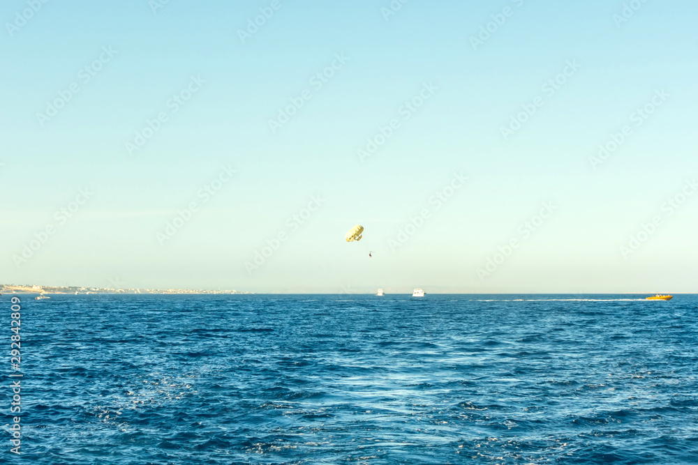 Parasailing over red sea in blue sky Parasailing over red sea in blue sky