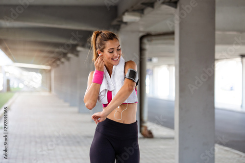young beautiful woman jogging  fitness outfit  listening to music on headphones  smartphone  sea sunrise  skinny perfect slim body  healthy living lifestyle  summer  smiling  happy