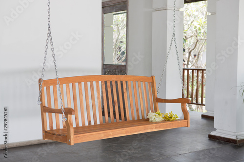 The brown wood swing in the backyard.