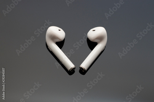 Wireless white headphones on black background close-up  top view