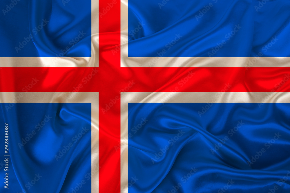Fototapeta premium photo of iceland state national flag on luxurious texture of satin, silk with waves, folds and highlights, closeup, copy space, illustration