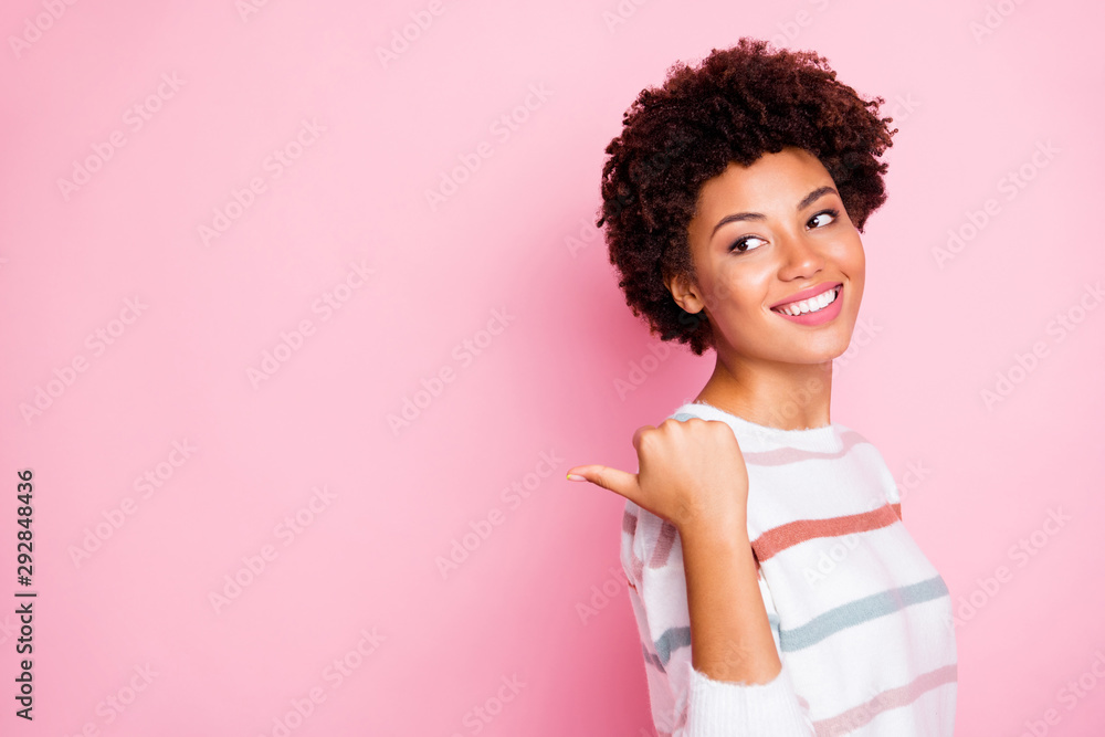 Photo of amazing dark skin wavy lady indicating finger empty space advising black friday low prices wear striped jumper isolated pastel pink color background Photo of amazing dark skin wavy lady indicating finger empty space advising black friday low prices wear striped jumper isolated pastel pink color background