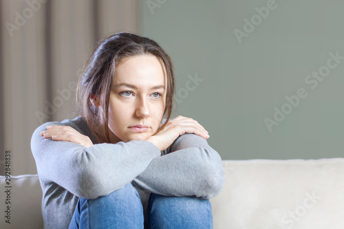 Fototapet Depressed young woman on sofa at home.
