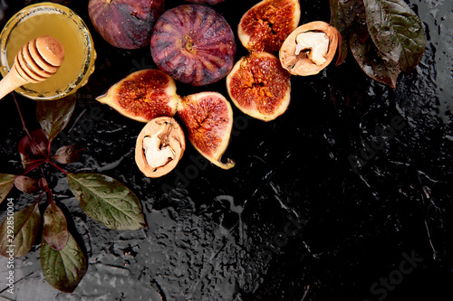 Autumn frame background. Autumn food still life with season fruits grape and figs, honey on a black table. Thanksgiving day. © bondarillia