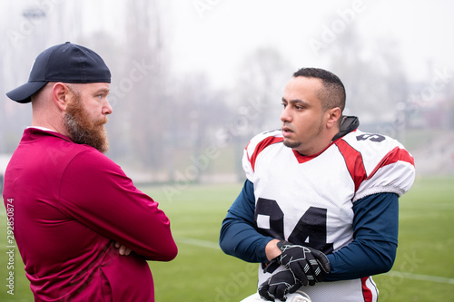 american football player discussing strategy with coach