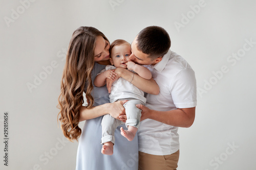 Happy Young Family Beautiful Mother And Father Kissing Their Baby Parents Portrait Of Mom Dad And Smiling Child On Hands Isolated Over White Background Stock Photo Adobe Stock