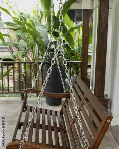 The detail of brown wood swing in the backyard.