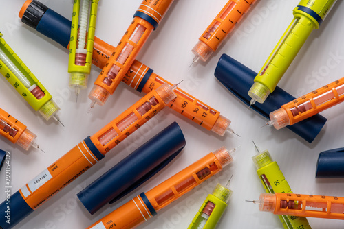 Stack of used insulin injectors or syringes of pen type photo