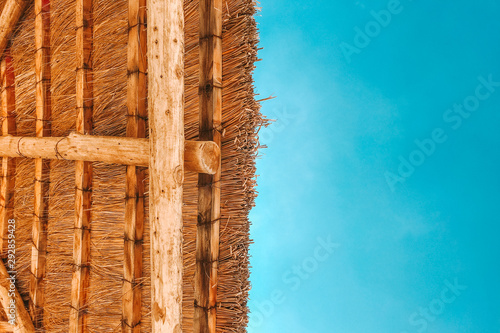straw beach umbrella with blue sky