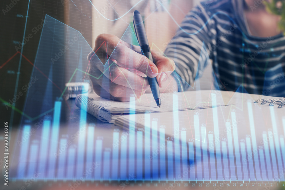 Financial forex graph drawn over hands taking notes background. Concept of research. Double exposure Financial forex graph drawn over hands taking notes background. Concept of research. Double exposure