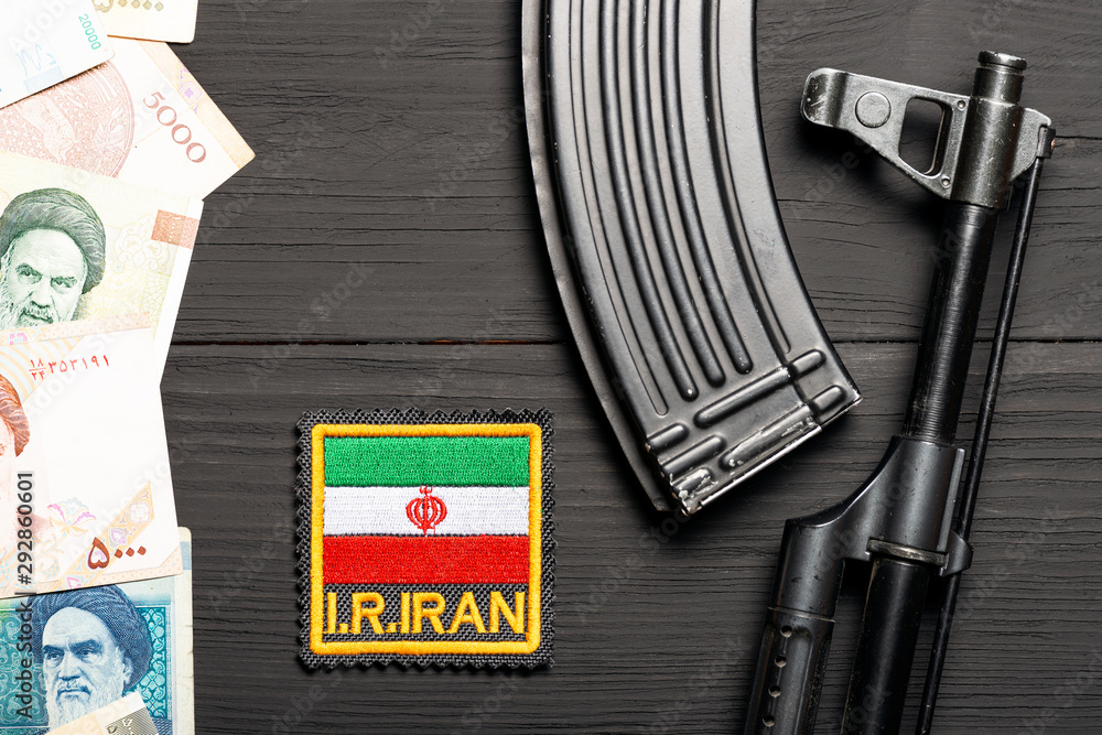 Obraz premium Soviet automaton AK 47 against the backdrop of Iranian money depicting Ruhollah Khomeini and Iranian flag
