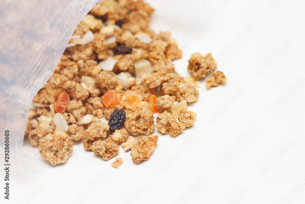 Granola with fruits and nuts in a transparent plastic bag. Baked muesli mix. Super food concept. Breakfast cereals. Kids diet. White isolation background. Granola with fruits and nuts in a transparent plastic bag. Baked muesli mix. Super food concept. Breakfast cereals. Kids diet. White isolation background.