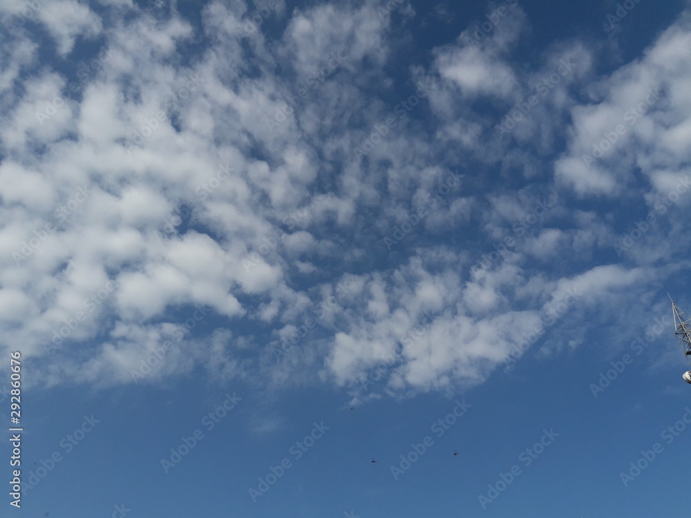 A beautiful horizontal shot of bright blue sky with puffy white clouds. A beautiful horizontal shot of bright blue sky with puffy white clouds.