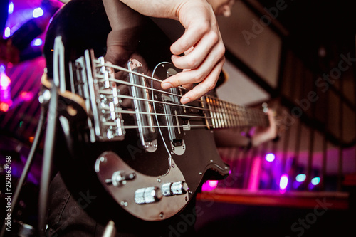 A man is playing guitar on stage, close-up.