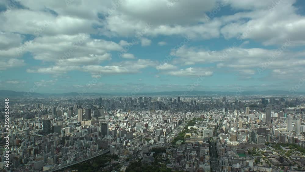 OSAKA, JAPAN - CIRCA SEPTEMBER 2019 : Aerial high angle view of CITYSCAPE of OSAKA in daytime. Osaka is the second largest metropolitan area in Japan. Time lapse shot. OSAKA, JAPAN - CIRCA SEPTEMBER 2019 : Aerial high angle view of CITYSCAPE of OSAKA in daytime. Osaka is the second largest metropolitan area in Japan. Time lapse shot.