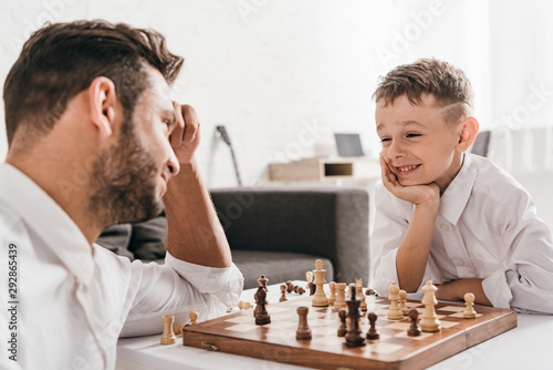 dad and son playing chess together at home