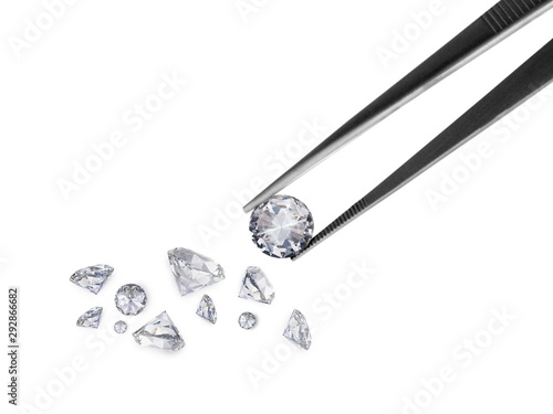 brilliant cut diamond held by tweezers photo