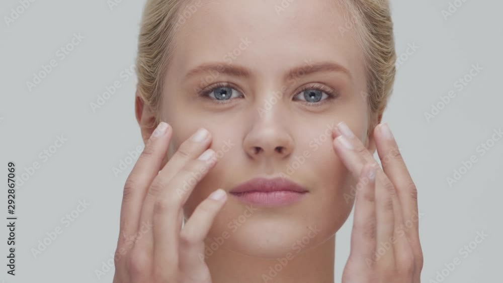 Studio portrait of young, beautiful and natural blond woman applying skin care cream. Face lifting, cosmetics and make-up. Studio portrait of young, beautiful and natural blond woman applying skin care cream. Face lifting, cosmetics and make-up.