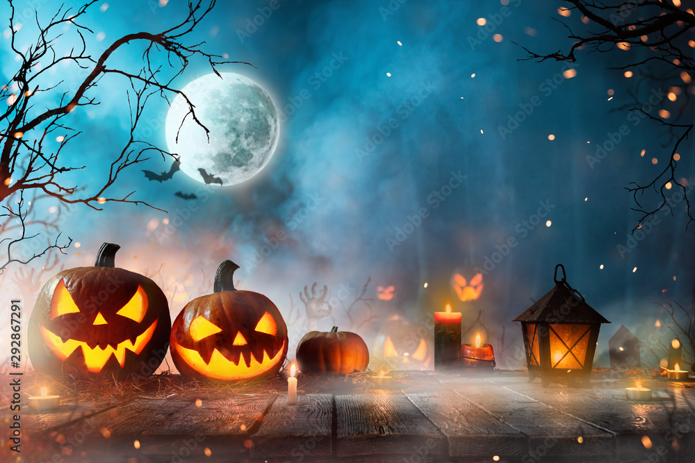 Fototapeta premium Halloween pumpkins on dark spooky forest with blue fog in background.