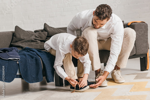 Εκτύπωση καμβά father teaching son to tying shoelaces at home