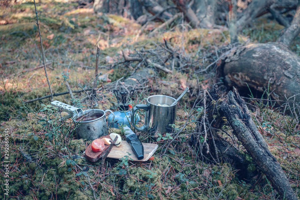 Kettle, gas burner and silicone mug close-up. Hiking in the forest.
