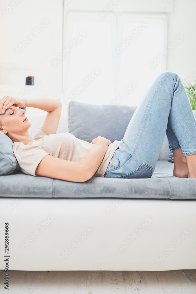 Woman with stomach issues / problems while lying on the couch. Woman with stomach issues / problems while lying on the couch.