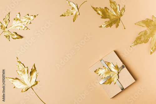 Fall and autumn flat lay with painted golden leaves on beige  background