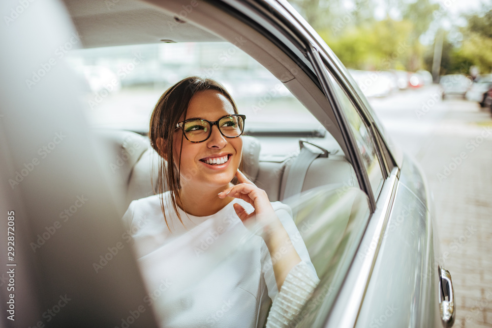 Portrait of a cheerful young woman traveling by a car and looking outside the window. Portrait of a cheerful young woman traveling by a car and looking outside the window.