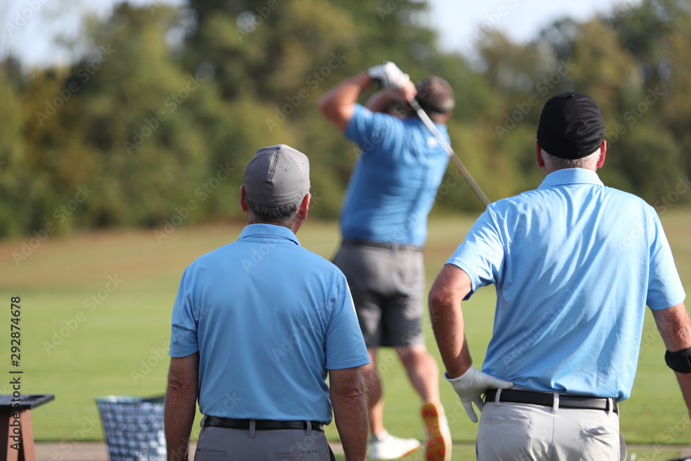 golfers watch a teammate warm-up prior to a tournament golfers watch a teammate warm-up prior to a tournament