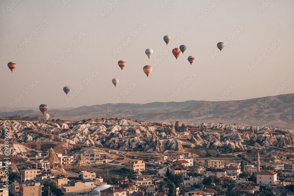 Landscape with a lot of hot air balloons in the sky over the city. Famous Turkish region Cappadocia with mountains and cave cities. View from below. Landscape with a lot of hot air balloons in the sky over the city. Famous Turkish region Cappadocia with mountains and cave cities. View from below.