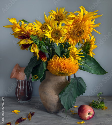 Still life with a flower of a sunflower and peaches. Beautiful bouquet of sunflowers. Ripe and tasty peaches. Vintage. Retro.