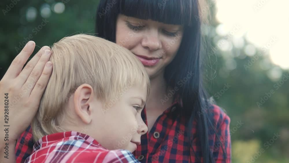 happy family mom and son concept . mom tender childhood video. lifestyle slow motion video. mom a brunette girl protects caress gently hugs takes care of the son boy blonde outdoors happy family mom and son concept . mom tender childhood video. lifestyle slow motion video. mom a brunette girl protects caress gently hugs takes care of the son boy blonde outdoors