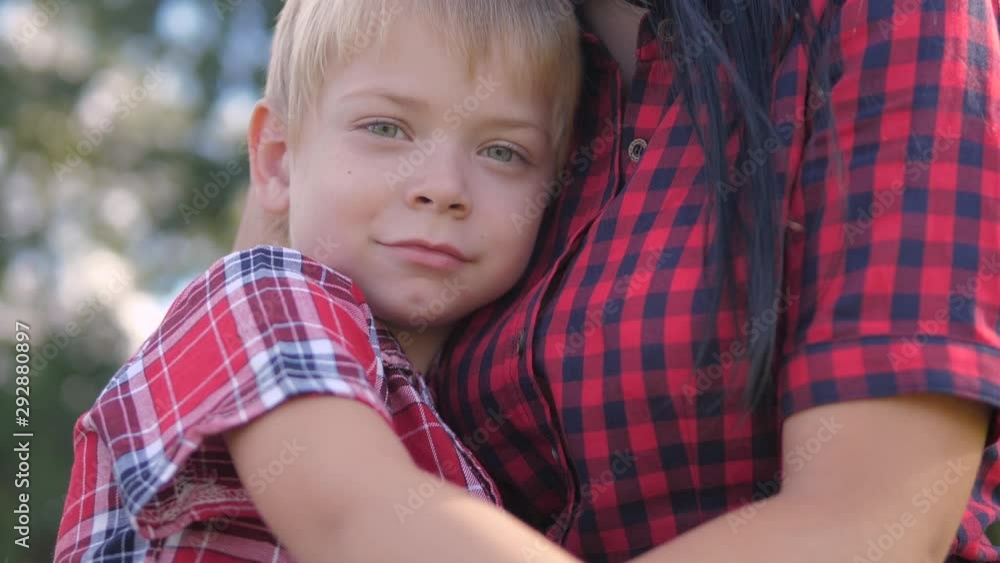 happy family mom and son sad child concept. mom tender childhood video. slow motion video. a mom brunette girl protects caress gently hugs takes care of the son blonde lifestyle boy outdoors happy family mom and son sad child concept. mom tender childhood video. slow motion video. a mom brunette girl protects caress gently hugs takes care of the son blonde lifestyle boy outdoors