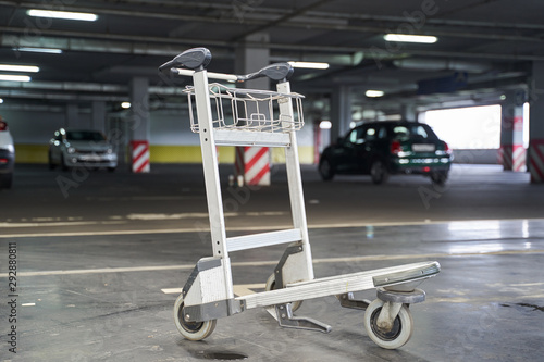 Photo of luggage trolley standing in underground parking lot
