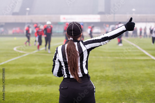 rear view of female american football referee photo