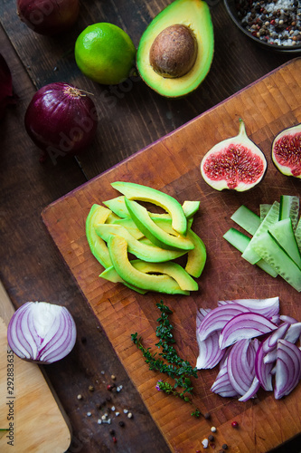 figs  avocado  cucumber  arugula  red onion  thyme on a cutting wooden board close-up - salad ingredients