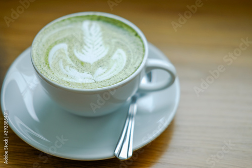 hot matcha green tea latte on wood table.