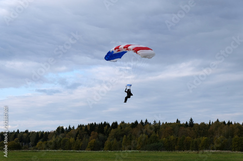 A skydiver is landing on the field.