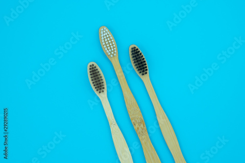 Wooden bamboo toothbrushes isolated on blue background. Concept dental eco-friendly...