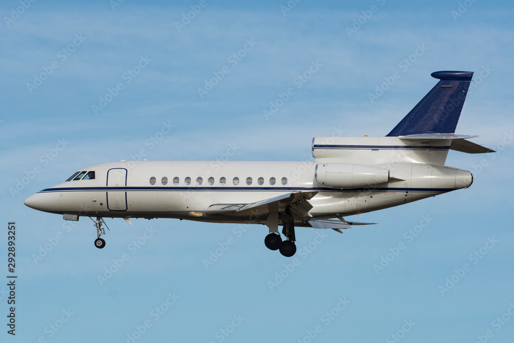 Obraz premium fotografía perfecta de un avión jet privado de perfil, tiene las ruedas desplegadas y a punto de aterrizar