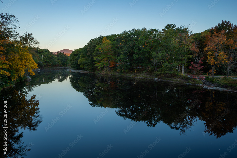 Fototapeta premium View of the Carrabassett River in Kingfield, Maine, during the foliage season. Looking north up the river towards the Sugarloaf area.