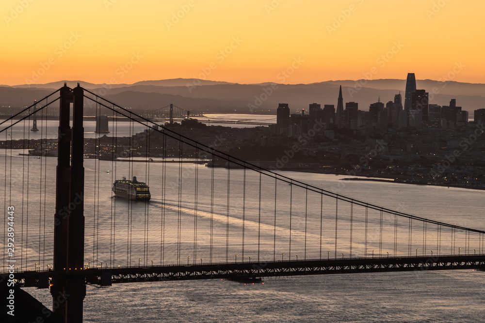 Fototapeta premium Golden Gate bridge in silhouette with a cruise ship coming into the San Francisco bay area