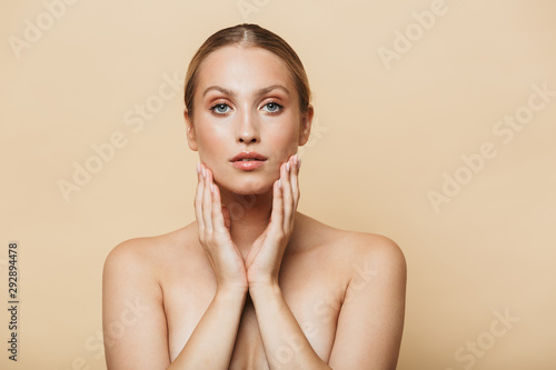 Image of alluring half-naked woman touching her face